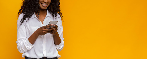 African american girl using cellphone on yellow background
