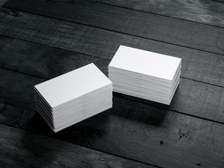Two Stacks of white business cards on black wooden table