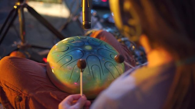 musician plays a percussion instrument with chopsticks