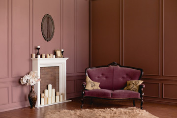 Elegant soft arm-chair near a fireplace. Luxury vintage interior in burgundy or brown colors....