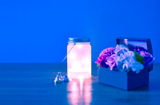 Chocolates with lanterns and small flower baskets on an outdoor table.