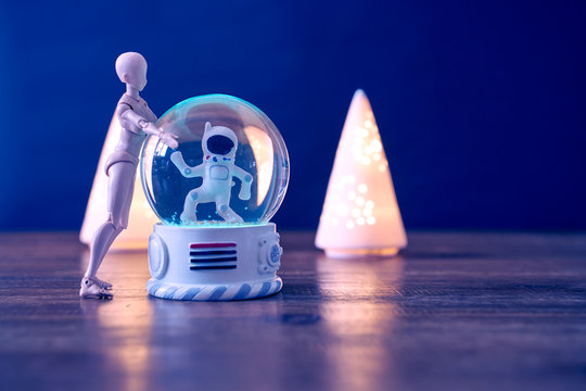 A spaceman meets an alien in a snowball.