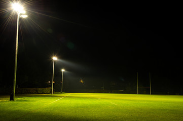 Green rugby field and goal posts with spotlight at night time, Rugby is the most popular sport in New Zealand.