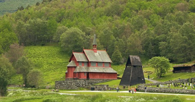 Borgund, Norway. People Walking Near Famous Norwegian Landmark Stavkirke An Old Wooden Triple Nave Stave Church In Summer Day. Panorama, Panoramic View