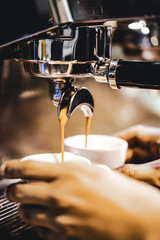 Espresso machine brewing a coffee. Coffee pouring into glasses in coffee shop, espresso pouring from coffee machine