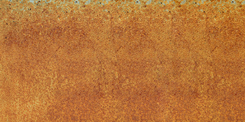 Panoramic bright red-orange iron sheet. Rust compound is an iron oxide. Deep rust, oxide and corrosion texture on a metal surface.
