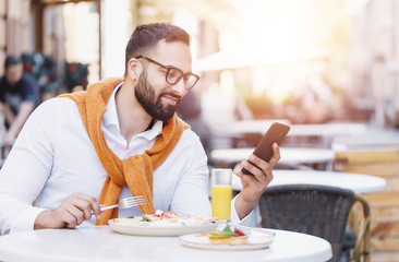 Bearded multicultural businessman in white shirt having phone conversation at the cafe