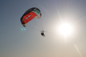 paragliding in the sky over the blue sea
