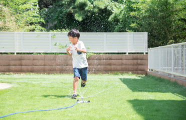 庭で水遊びをする男の子