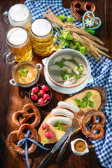 Bavarian sausages with pretzels, sweet mustard and beer mugs