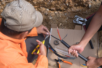 Electrical engineer technician fixing high voltage underground cable wire installation...