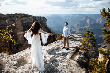 The girl in a chic dress spread her arms like a bird, the guy is standing opposite. Spectacular...