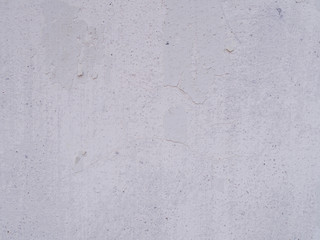 White dirty peeled plaster wall with falling off flakes of paint. Background texture.      