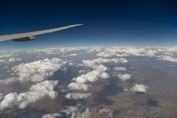 Airplane Wing and Clouds Viewed from Inside the Aircraft. Travel concept with copy space.