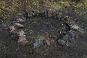 Campfire fireplace fire hole pit made of stones in nature