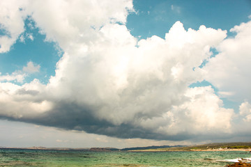 plage sous gros nuage, mer turquoise