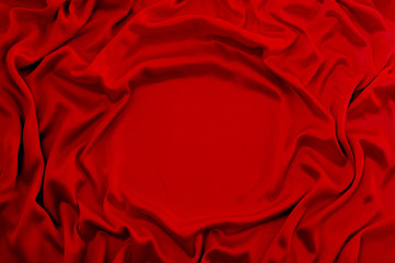 Obraz premium Photograph of silk fabric, color red. The texture of silk fabric. Luxury silk fabric background with waves and drapery. Background for fashion luxury design, close-up, copy space
