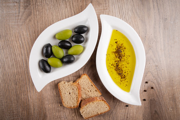 Frisches Olivenöl, Oliven und knuspriges Brot