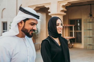Fotobehang Happy couple spending time in Dubai. man and woman wearing traditional clothes making shopping in the old city © oneinchpunch