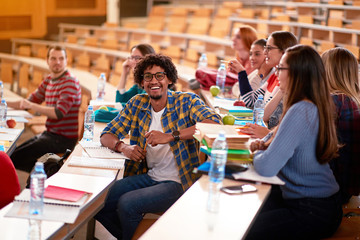 Smiling Multiracial students studying together.