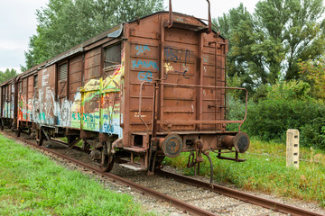 Fototapeta na wymiar Vienna, Austria-September 06,2012:.old rusty wagon with graffiti standing abandoned on in track