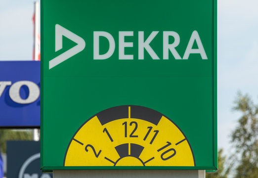 Stade, Germany - August 22, 2019: Signage on pole, identifying a DEKRA vehicle inspection workshop.