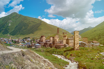 Fototapeta na wymiar View of the Ushguli village at the foot of Mt. Shkhara. Picturesque and gorgeous scene. Rock towers and old houses in Ushguli, Georgia.