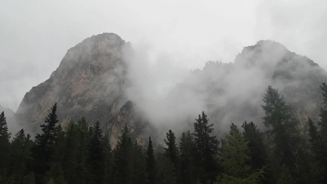 Mountains engulfed in fog and clouds on a rainy day in Vallunga valley, Selva, South Tyrol, Italy.