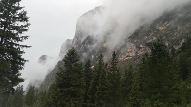 Mountains engulfed in fog and clouds on a rainy day in Vallunga valley, Selva, South Tyrol, Italy.