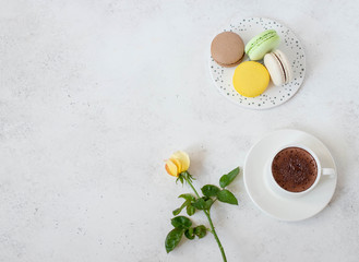 cup of hot chocolate with macarons flowers on a white background