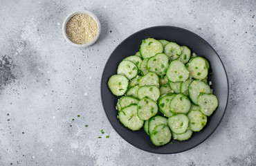 salad with fresh cucumbers sesame and herbs on a light background
