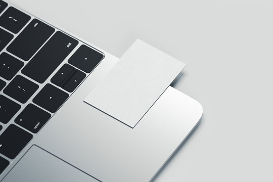 Close up of white realistic modern business card on laptop on light background. 3d rendering.