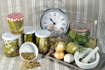 time to pickled. to keep long time. Pickled cucumbers in glass jar with clock, herbs and dill spices, on a fabric linen background. Natural products ready for winter. organic and healthy meal concept.