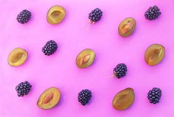 Obraz na płótnie Canvas plums and blackberry-fruits on a pink background