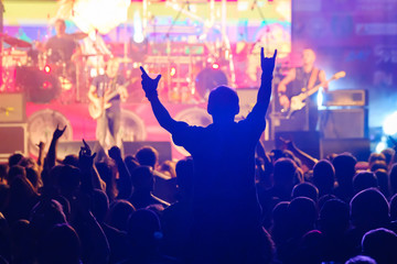 Fototapeta na wymiar Fans at live rock music concert cheering