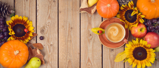 Autumn harvest concept with pumpkin, apples and sunflowers on wooden table. Thanksgiving holiday background. Top view from above