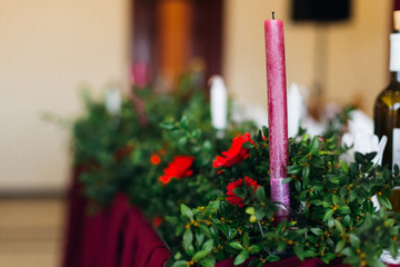 marsala color candle on a wedding table decorated with green bra