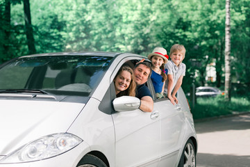 happy family with children sitting in a family car