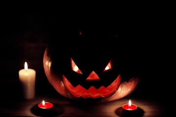 candles and pumpkin for Halloween in a cramped room