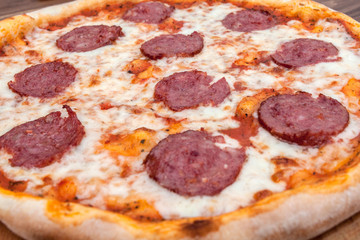 Italian Pepperoni pizza with salami on dark wooden background top view. Italian traditional food. Popular street food