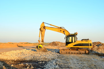 Excavator with crusher bucket for crushing concrete. Construction waste recycling for construction mix. Sifting and grinding bucket for the separation of concrete into fractions of higher quality.