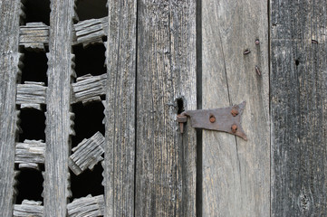antique wooden window closed by an old rusty lock