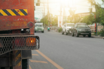 The back of the truck on the asphalt road with open signal light.