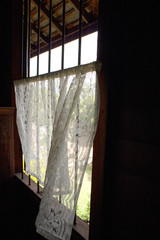 A white lace curtain at  the old style window