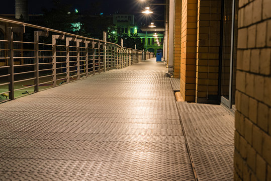 Illuminated walkway with railing, Walkway made of stall plates, Walkway at night