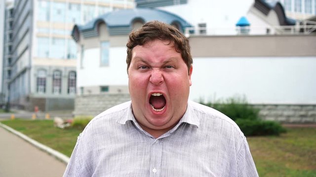 Handsome screaming young man portrait. Anger men looking at camera
