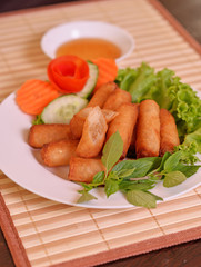  Spring Rolls, on white dish and wooden table / Selective focus