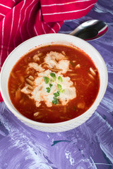 A view of a bowl of tomato soup with sour cream.