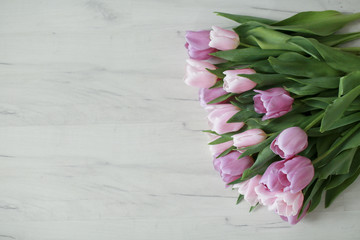 Bouquet of pink flowers lies on a wooden floor