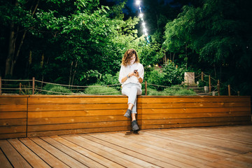 Smiling young woman sitting relaxed on bench